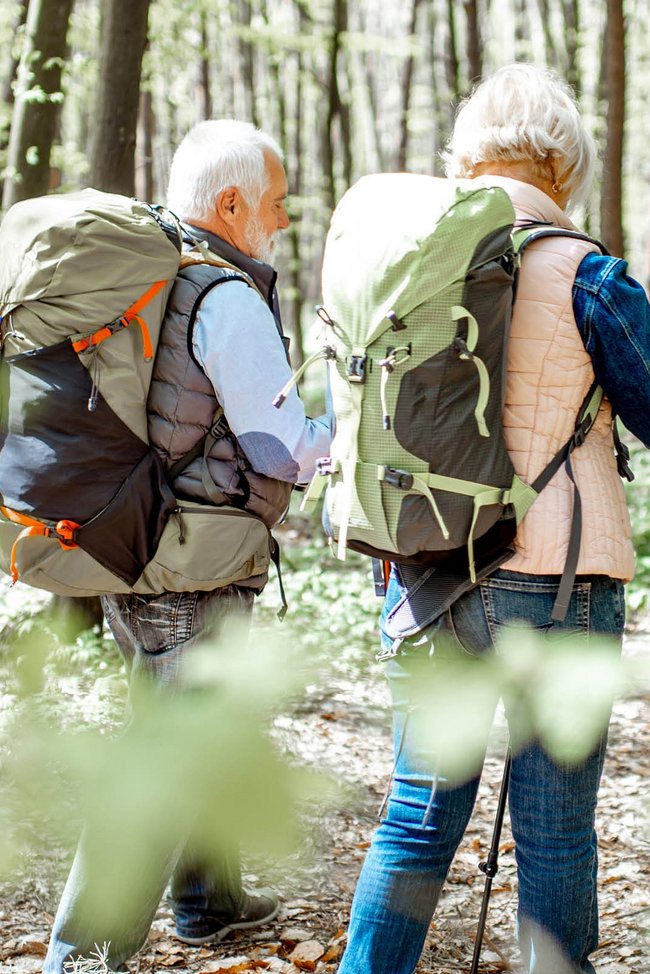 Zwei Senioren wandern durch den Wald.