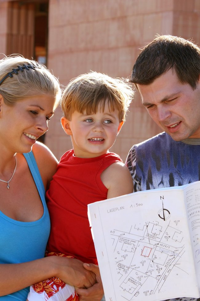 Junge Familie vor dem Rohbau